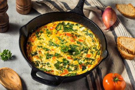 Омлет со шпинатом, помидорами и сыром на сковороде